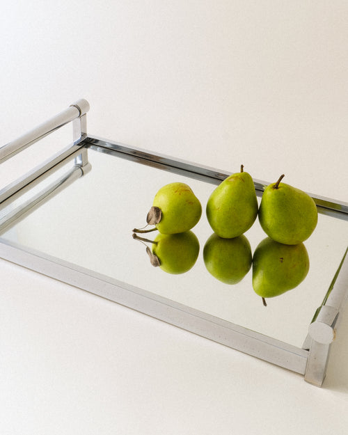 Adnet table mirror from the 1940s with green pears reflected in the glass
