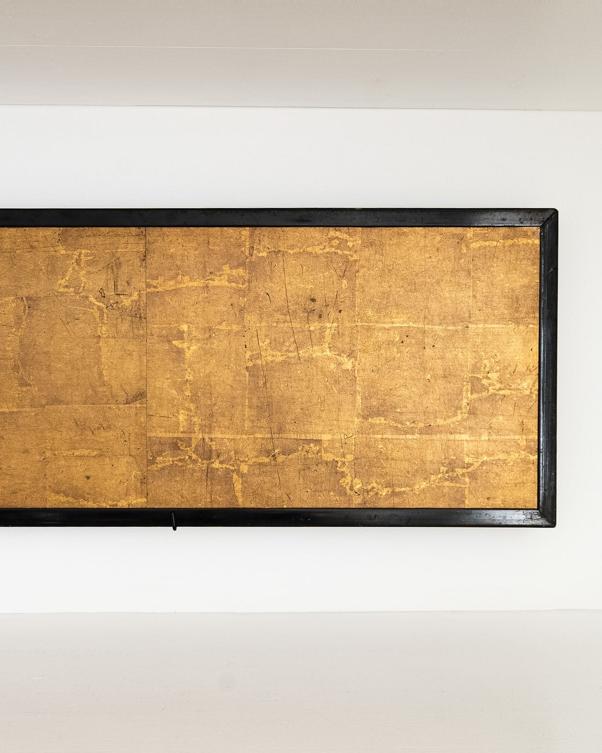 Detail of the Japanese screen’s right panel, showing aged gold leaf and the black lacquered frame.