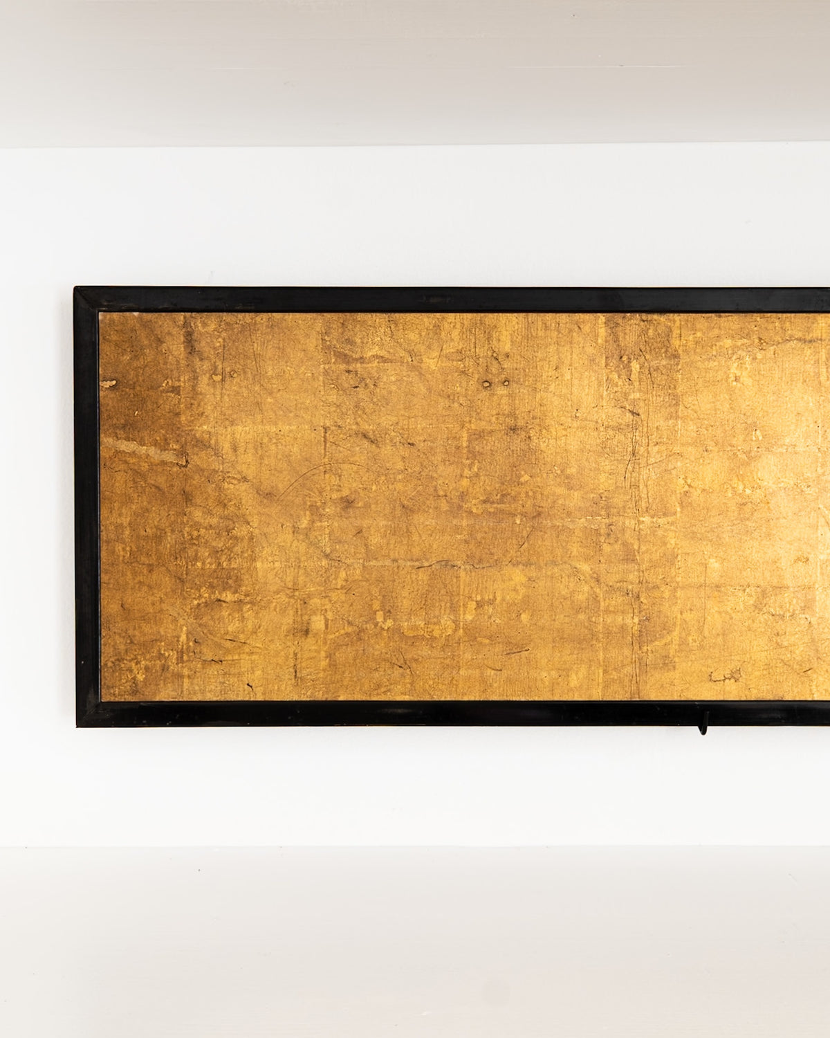 Detail of the Japanese screen’s left panel, showing aged gold leaf and the black lacquered frame.