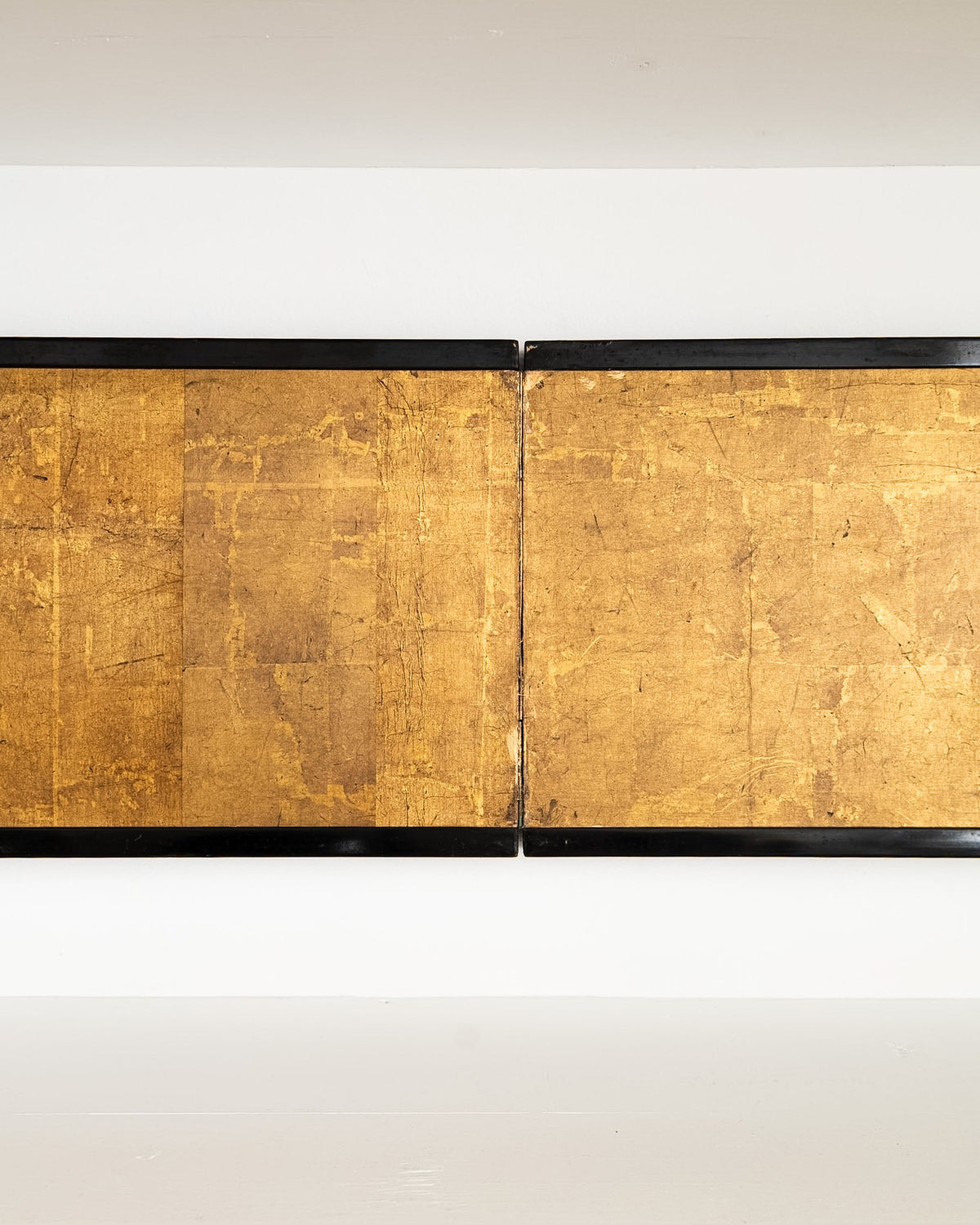 Detail of the Japanese screen’s middle panel, showing aged gold leaf and the black lacquered frame.