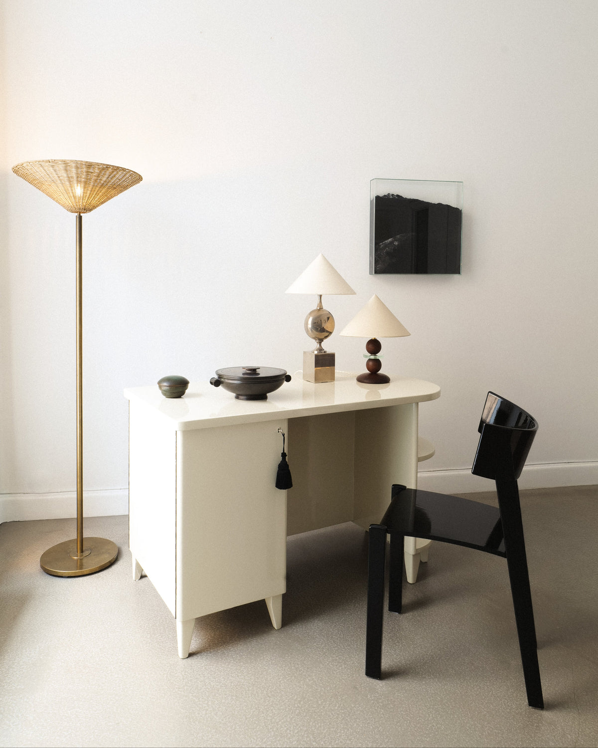 Bronze lidded dish displayed on a white desk in a minimal interior
