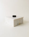 Rectangular Carrara marble lidded box with a round black agate handle
