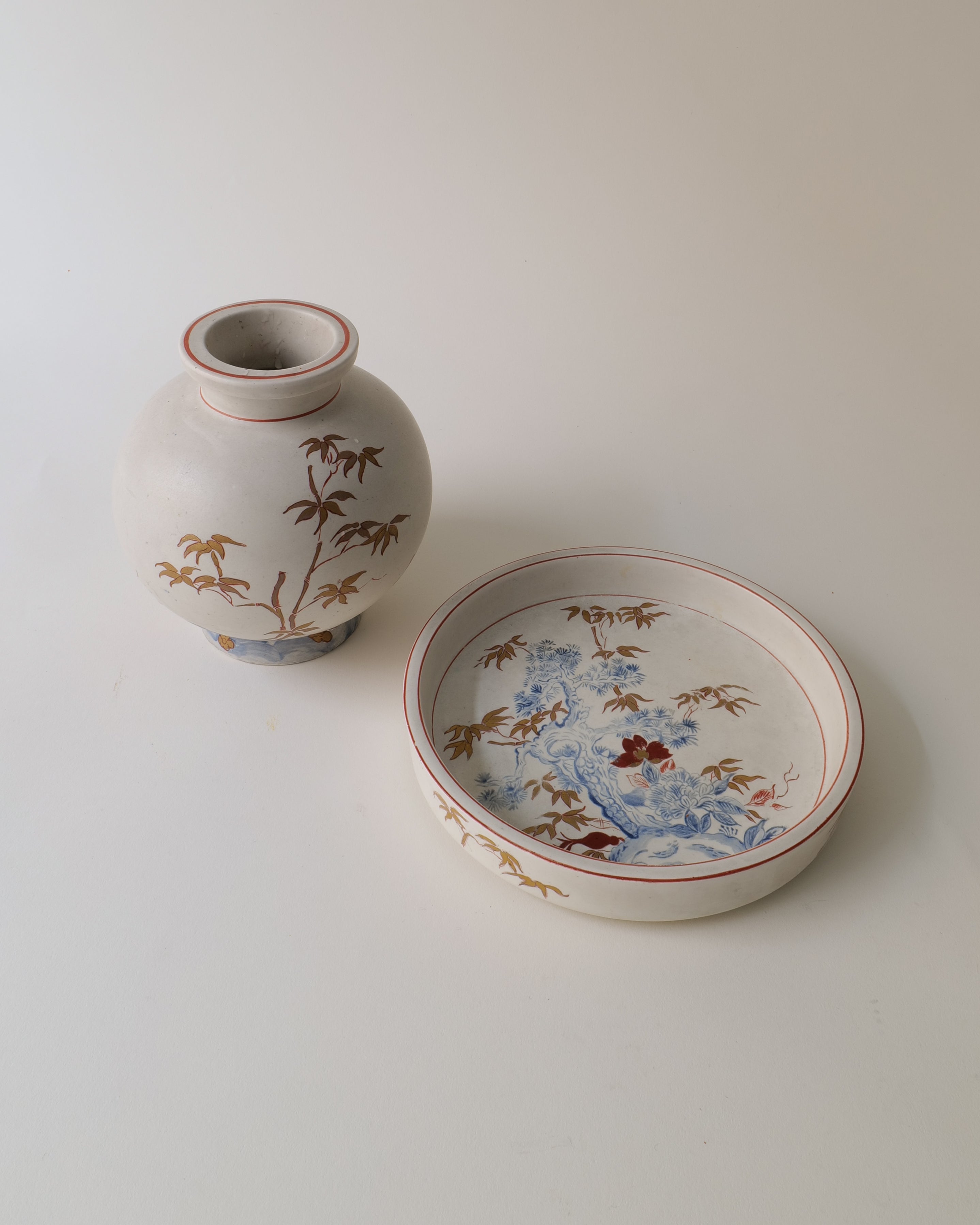 Ceramic vase by Wilheml Kåge with floral design and a matching bowl on a light background