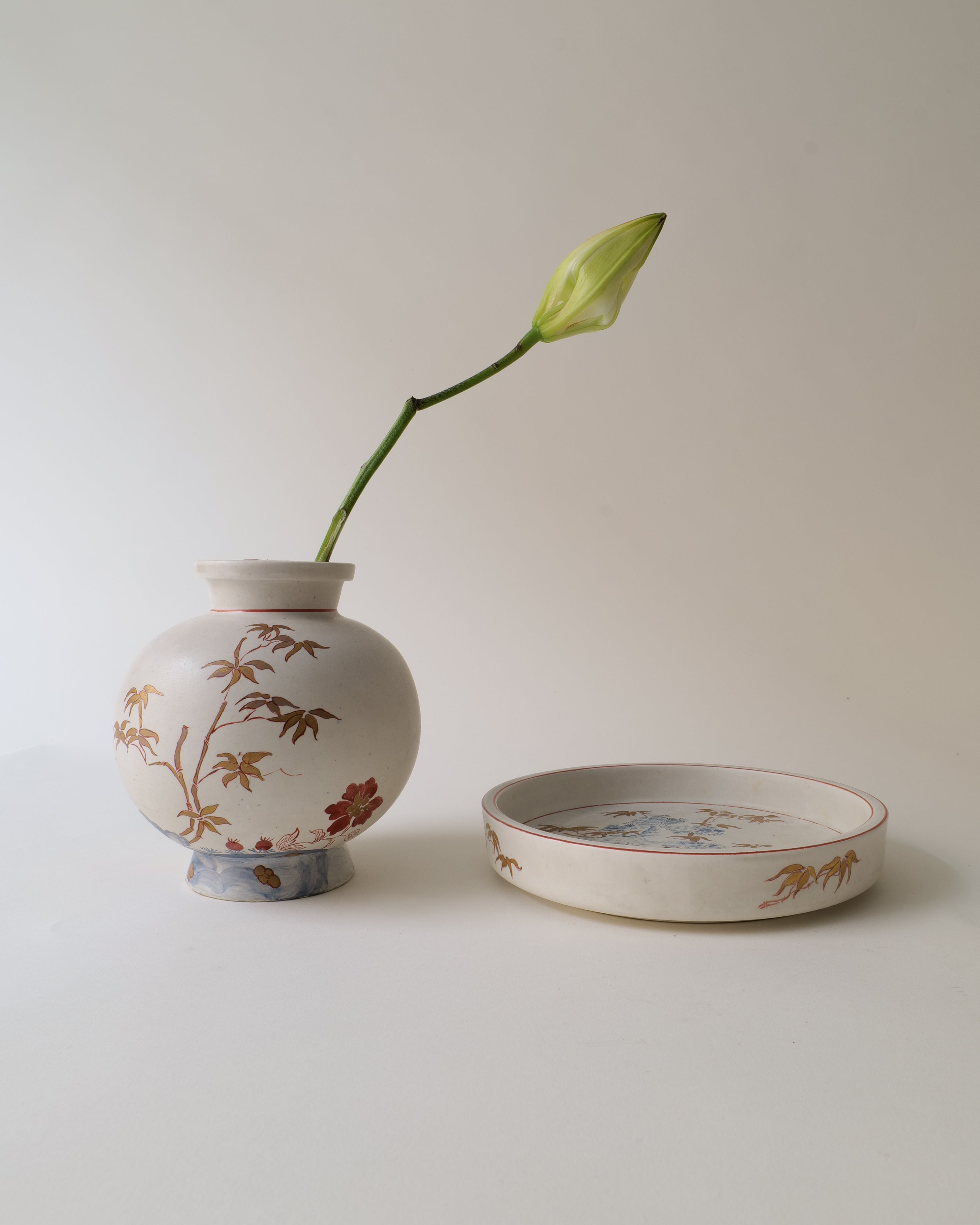 Ceramic vase by Wilheml Kåge with floral design and a matching bowl on a light background