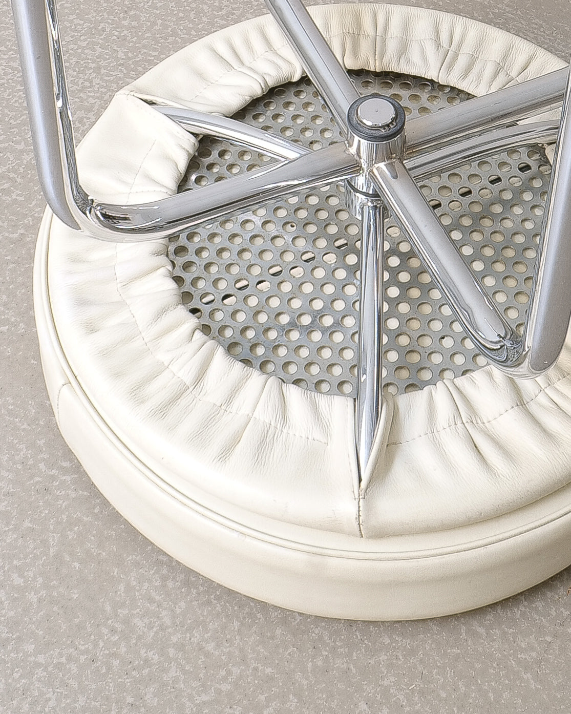 Charlotte Perriand LC8 stool, underside showing chrome swivel mechanism and serial number 9851