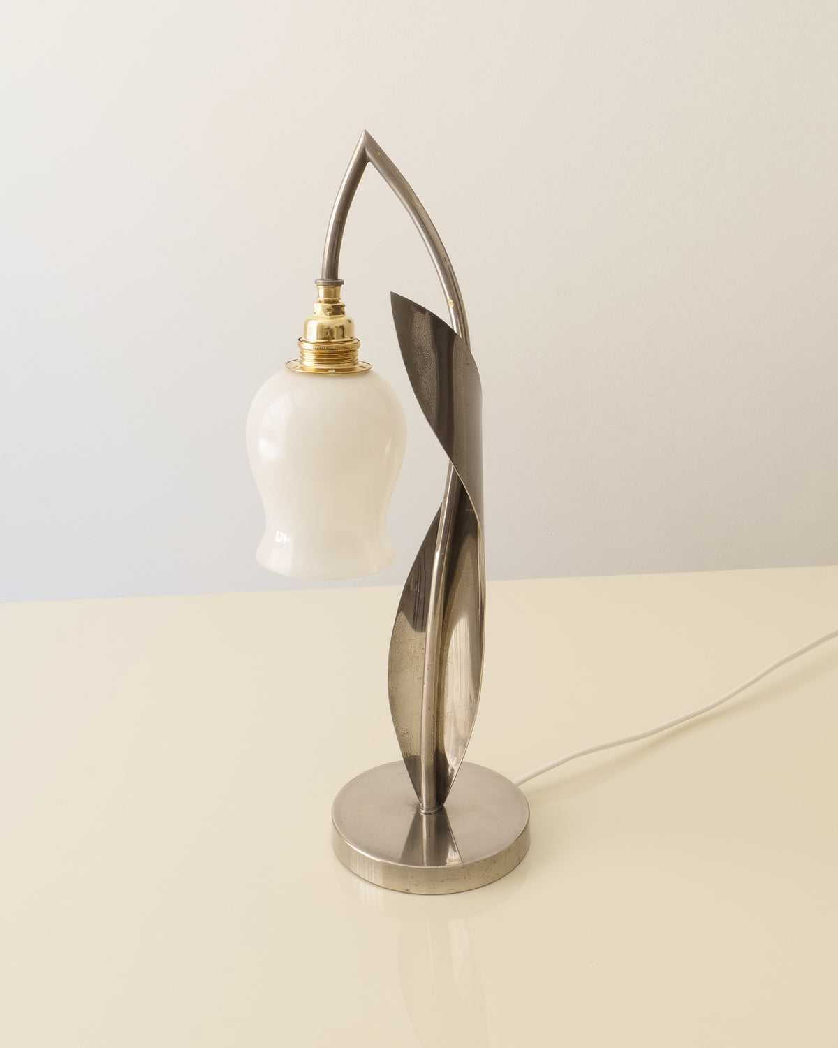 Chrome and opaline glass lily-of-the-valley lamp shown from an angled front view
