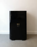 Black cabinet with two handles on a plain background