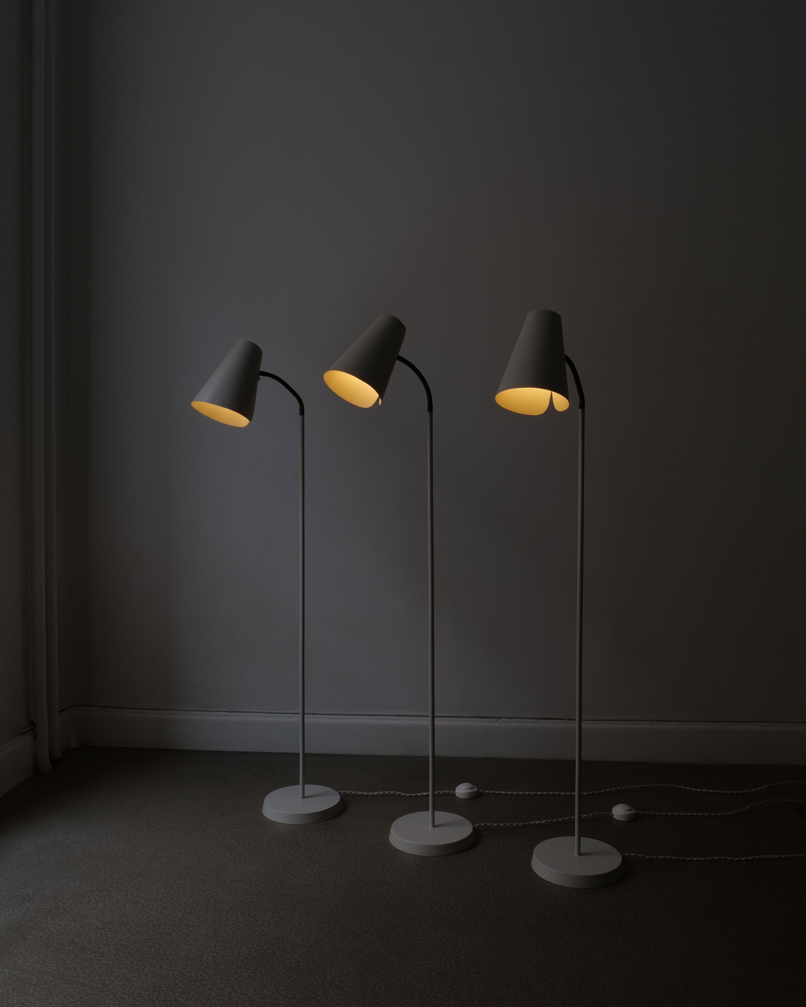 Set of three Harald Notini Model 225 floor lamp by Böhlmarks, full view, lit in dark room, matt Grey White re-lacquered body, 1930s–40s