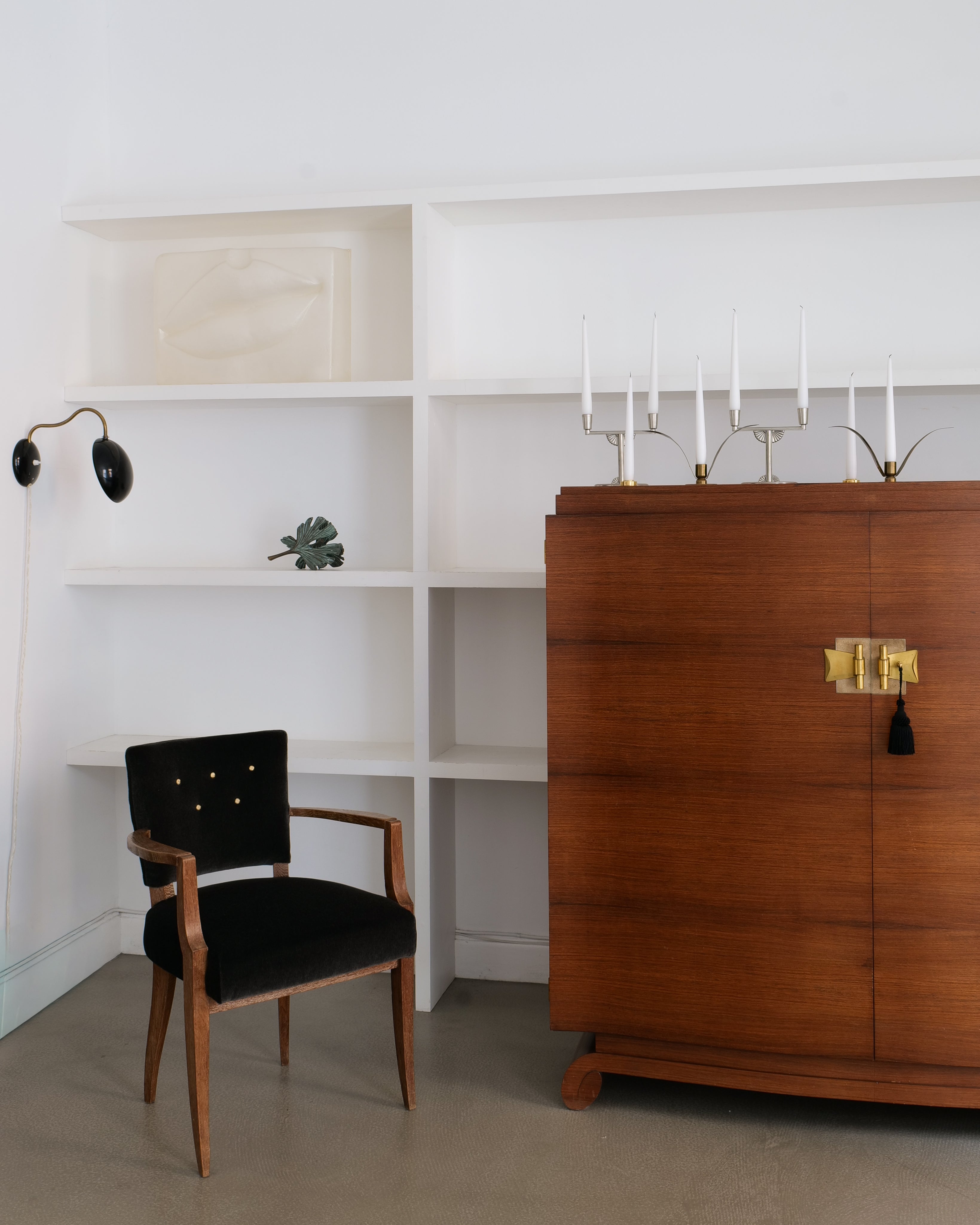 Jules Leleu wooden cabinet with black chair in a minimalistic room