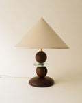 French modernist table lamp with sculptural wood base, glass detail and conical white shade
