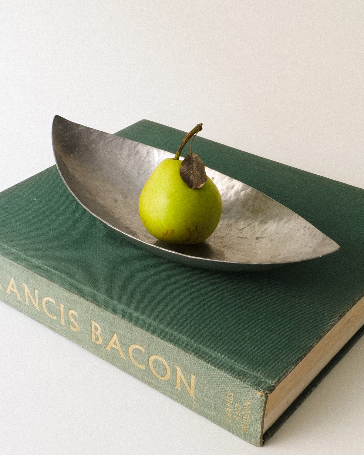 Swedish leaf-shaped pewter bowl by Erik Torssell shown from an angled side view
