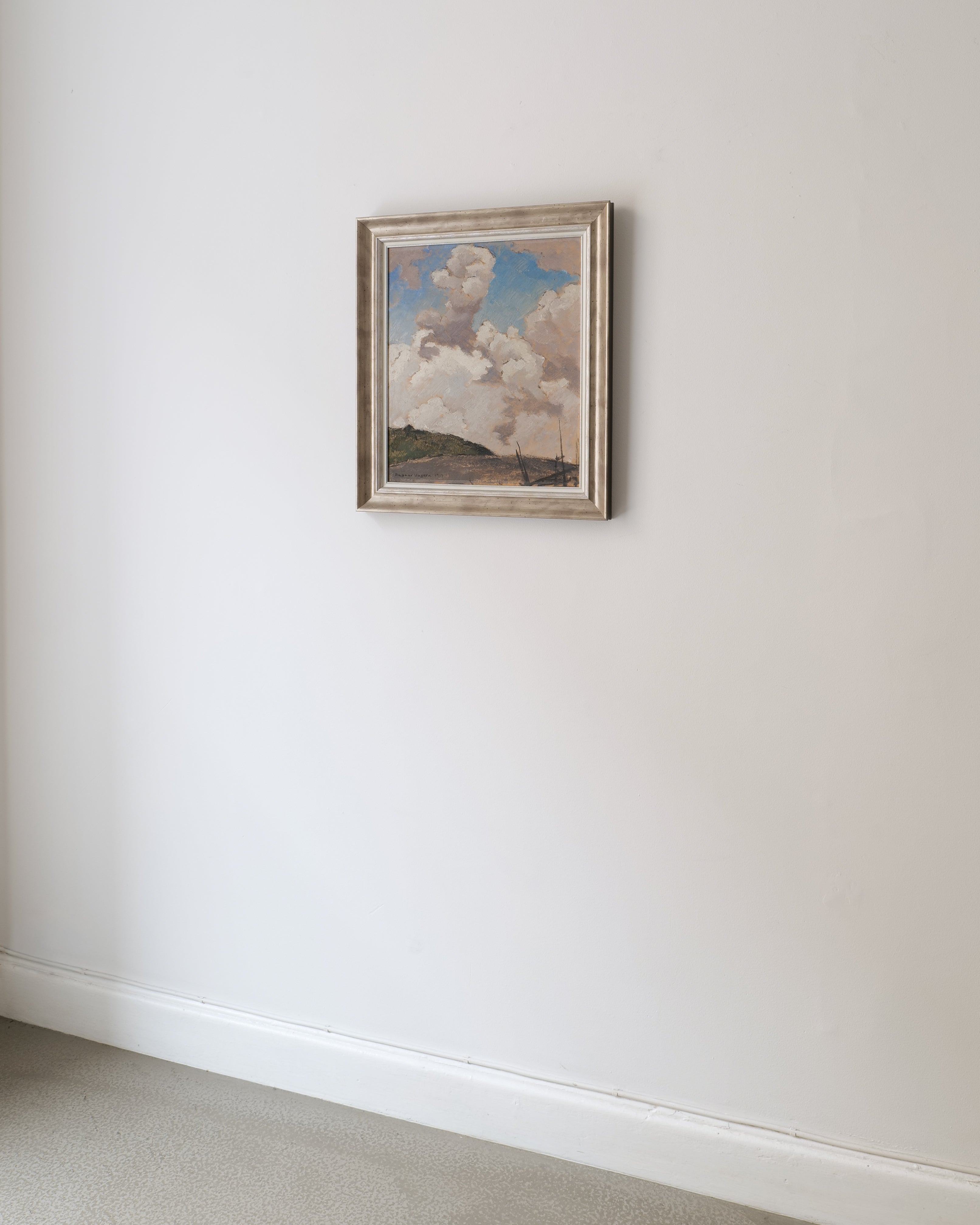Framed artwork of a cloud on a white wall