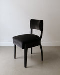 Front view of René Prou accent chair – rounded back and tapering legs in ebonised wood