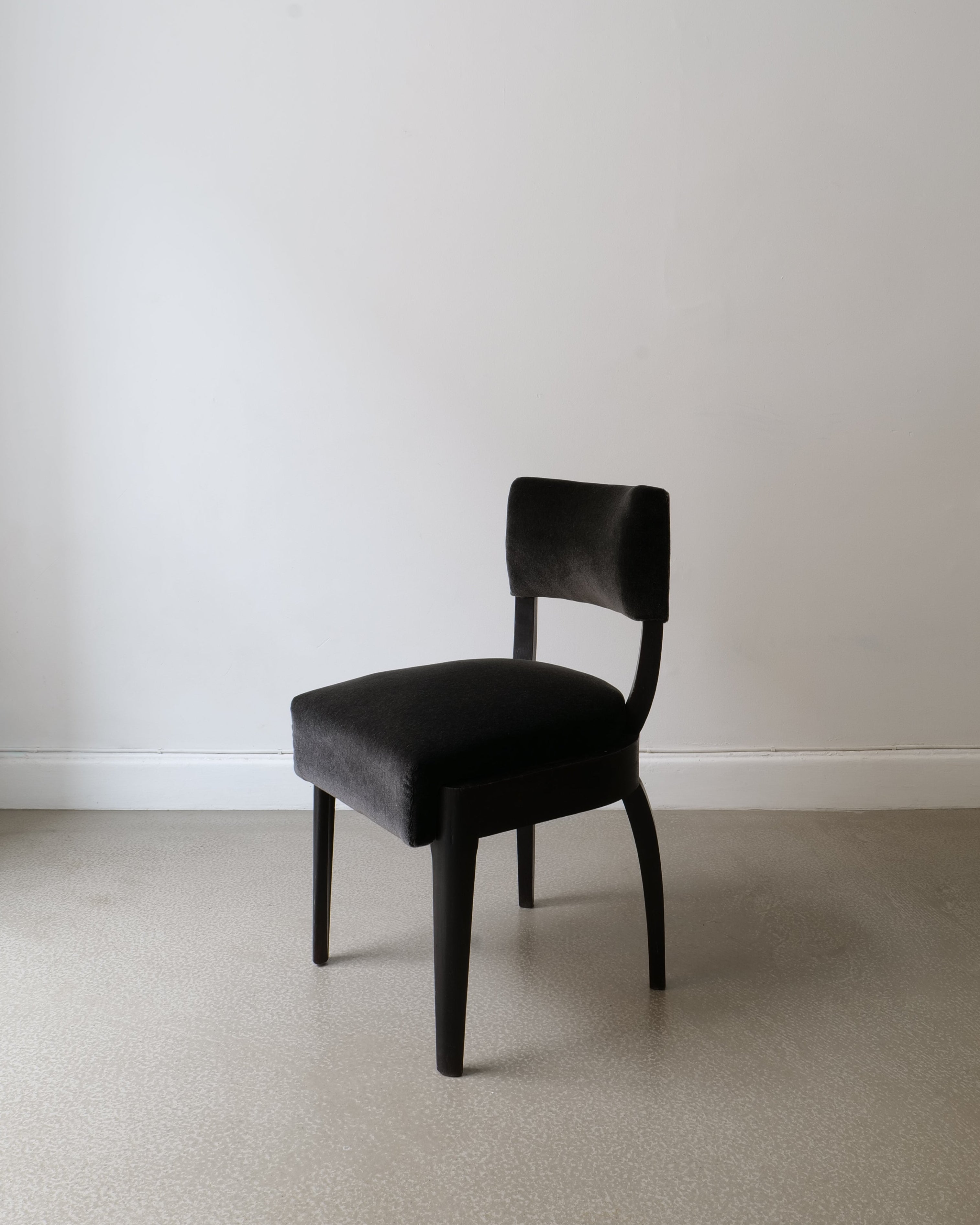 Front view of René Prou accent chair – rounded back and tapering legs in ebonised wood