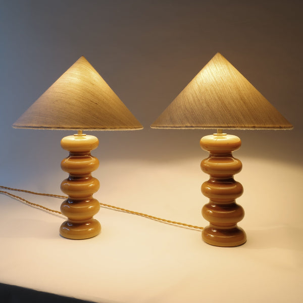 Two ceramic table lamps with cone-shaped lampshades on a neutral background