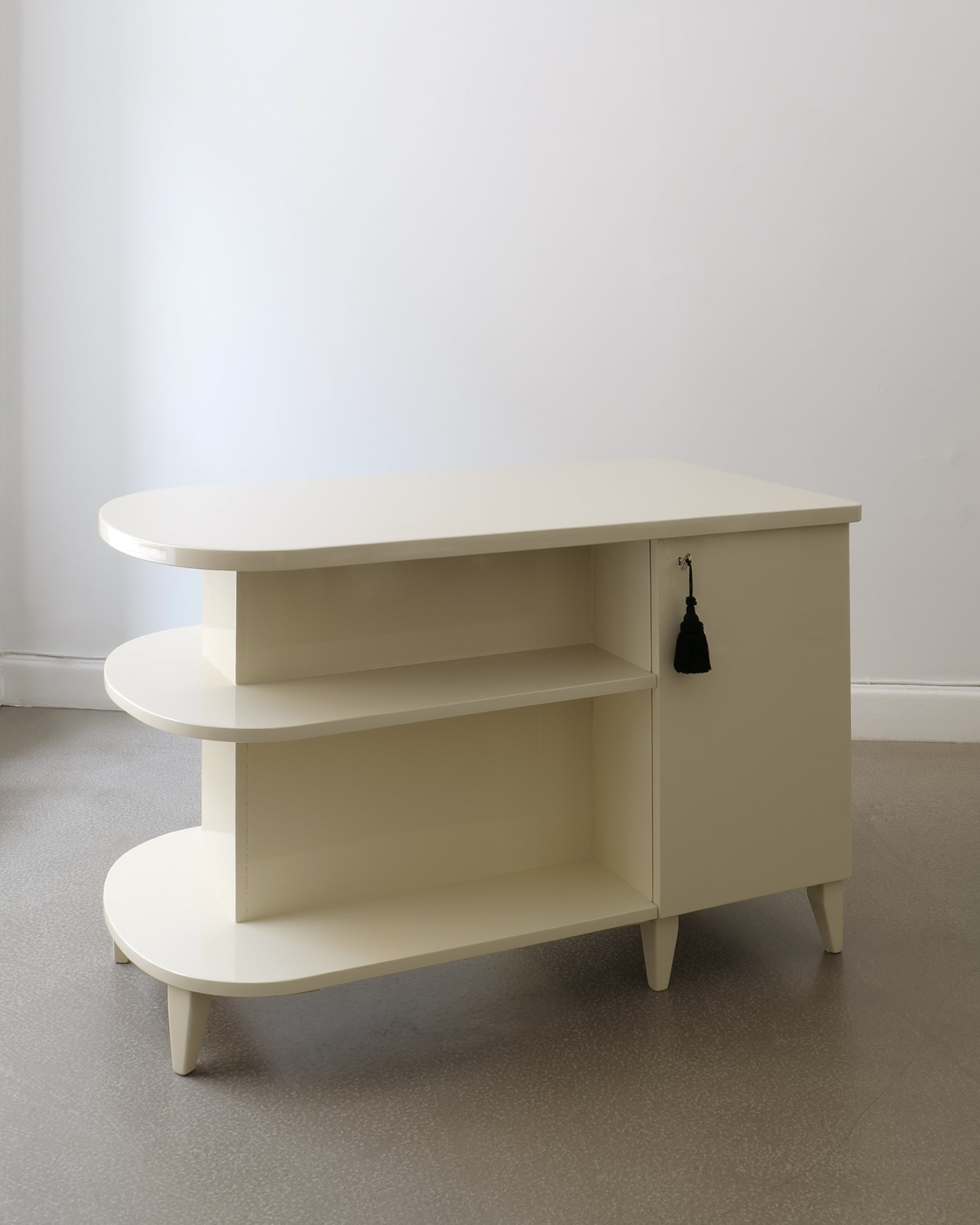 Swedish Art Deco lacquered desk, front-right view, closed cabinet doors and tiered shelves